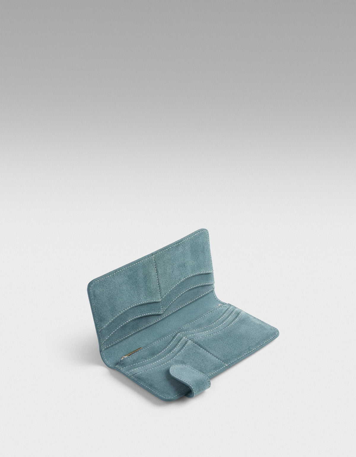 Blue suede Fluctus long wallet opened to show its card slots and zip pocket